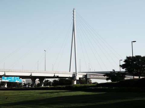 A modern cable-stayed bridge with a tall central pylon against a clear sky.