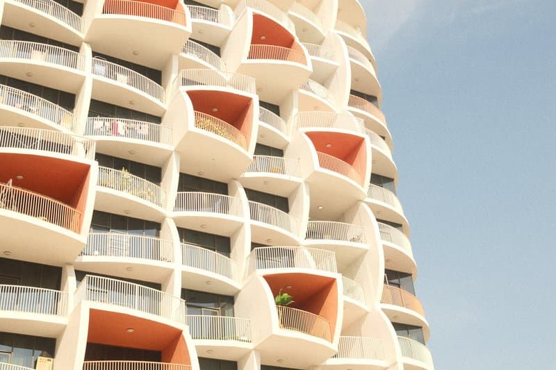 Close-up of a modern building facade with unique balcony designs against a clear sky.