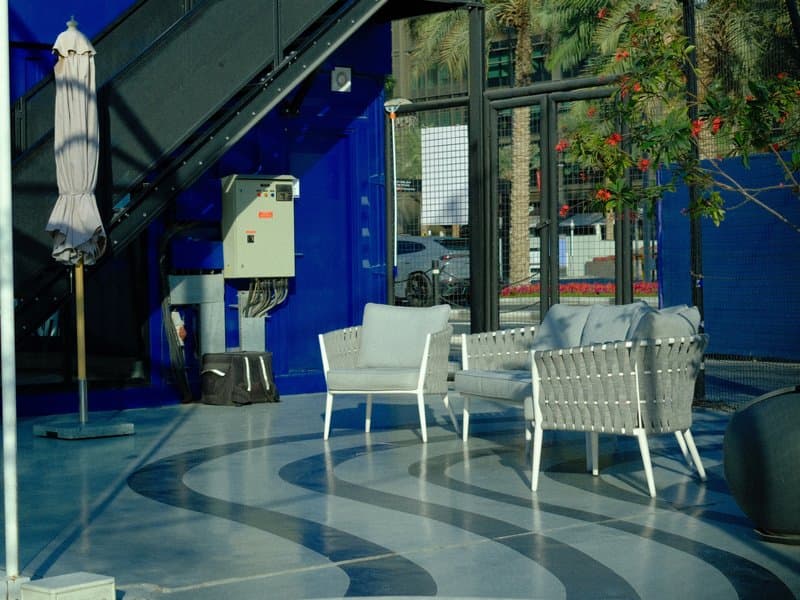 A modern indoor seating area with two white chairs and a blue wall backdrop.
