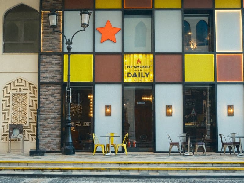 Colorful facade of a cafe with a star sign and outdoor seating in an urban setting.