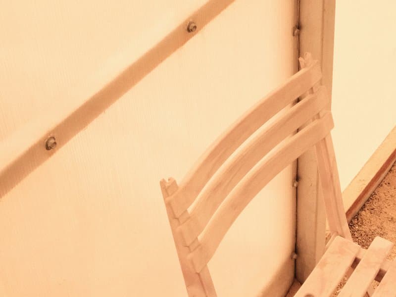 A wooden chair against a light-colored wall, showcasing simple lines and textures.