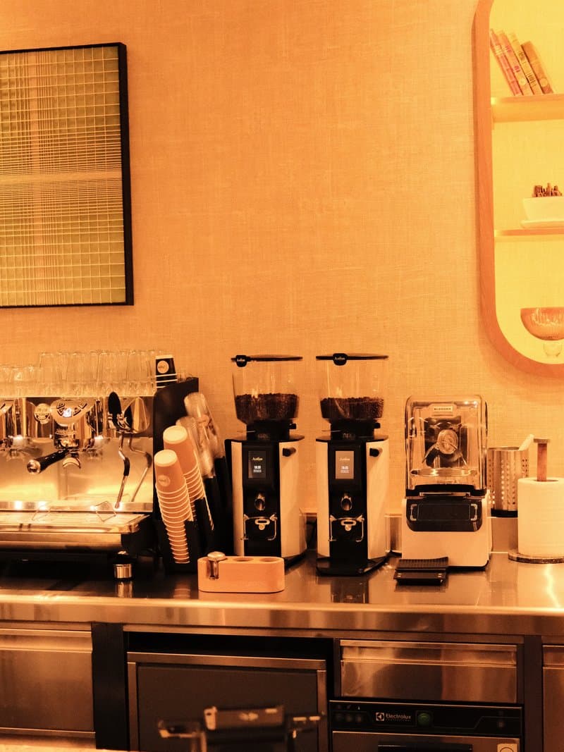 A modern coffee bar setup featuring espresso machines, grinders, and a clean countertop.