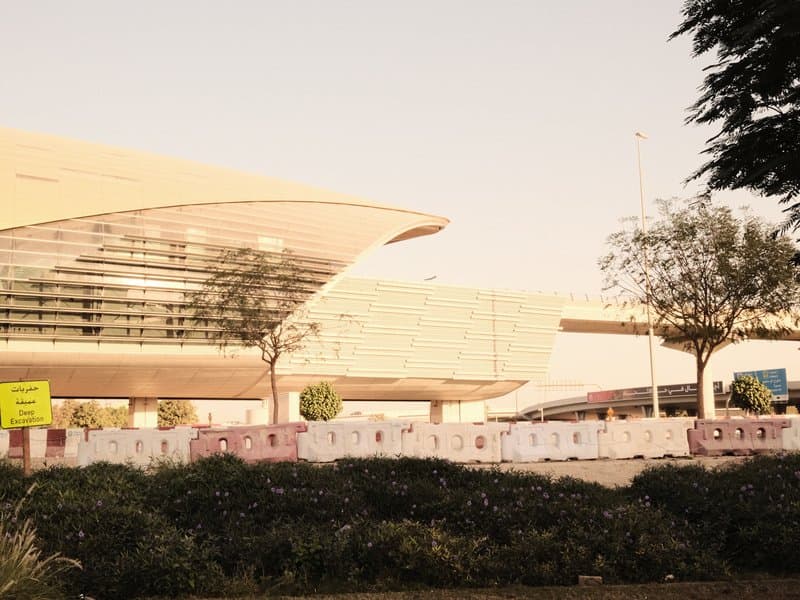 Modern architectural structure with trees and a clear sky in the background.