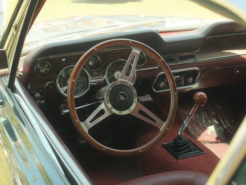 Interior view of a vintage car showcasing the steering wheel and dashboard details.