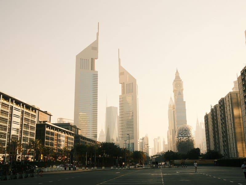 City skyline with modern skyscrapers under a warm golden hour light.