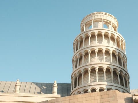 A close-up view of the Leaning Tower of Pisa against a clear blue sky.