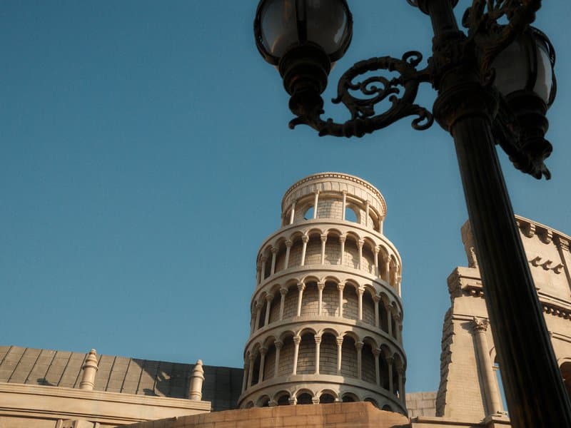 A close-up view of a historic tower with a clear blue sky in the background, featuring a decorative lamp post.