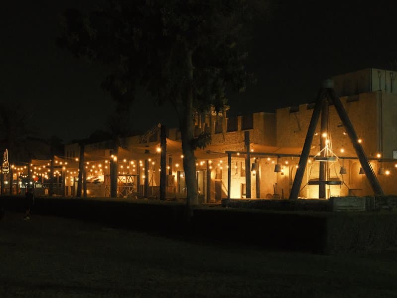 A dimly lit outdoor restaurant with string lights illuminating the space at night.