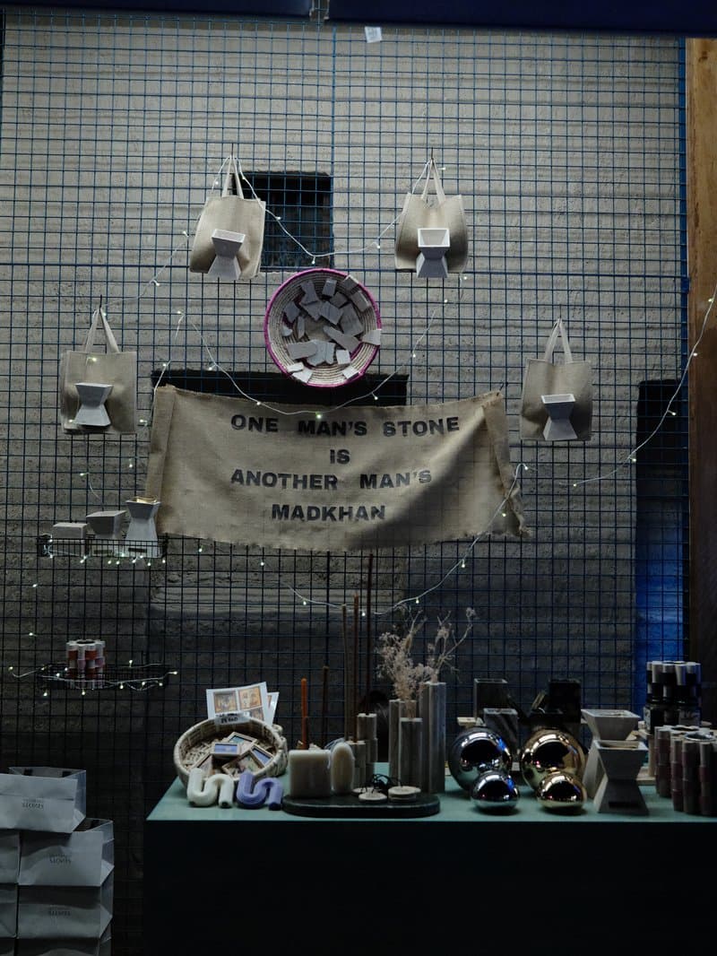 A display of handmade goods in a shop window with a banner and various products arranged on a table.