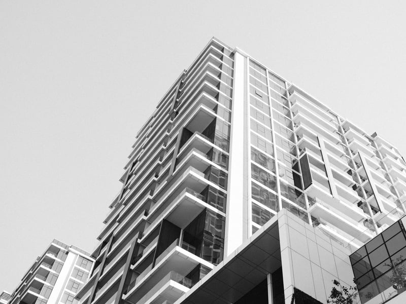 A modern high-rise building viewed from below against a clear sky.