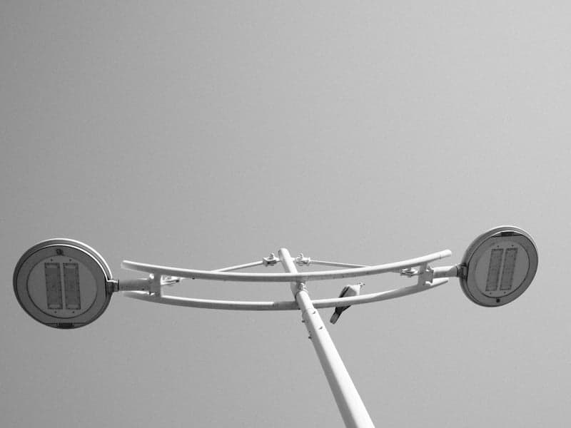 Low-angle view of a modern street lamp against a clear sky.