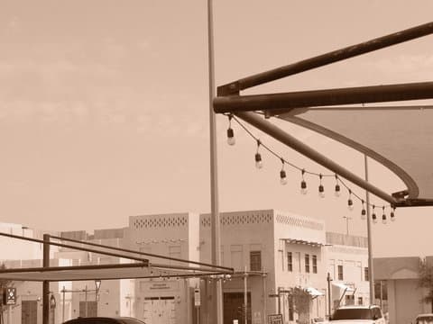 A sepia-toned urban scene featuring buildings and decorative lights under a canopy.