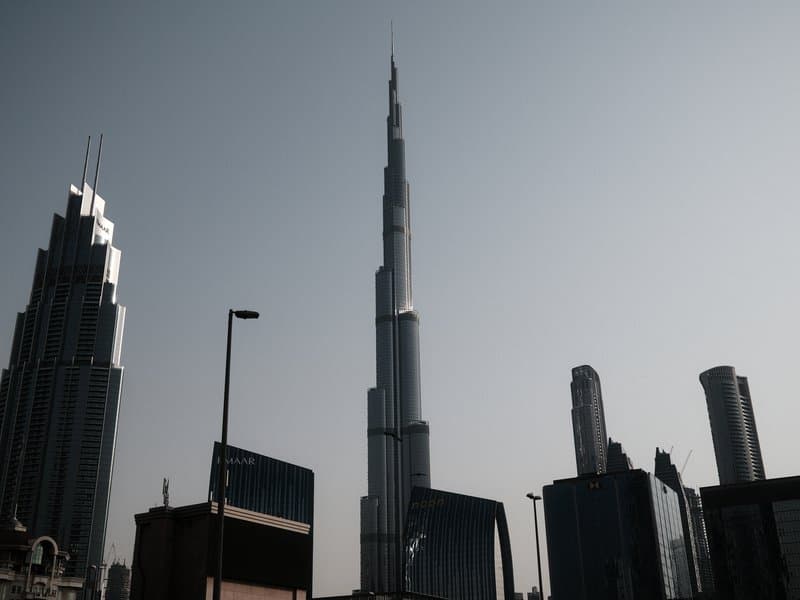 Silhouette of skyscrapers including the Burj Khalifa against a hazy sky.