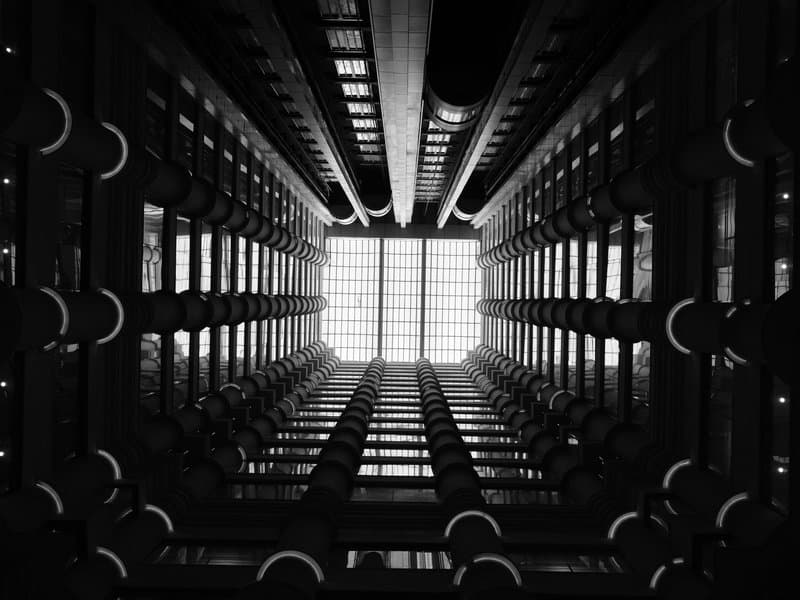 Looking up through a modern building's atrium with geometric patterns and bright skylights.