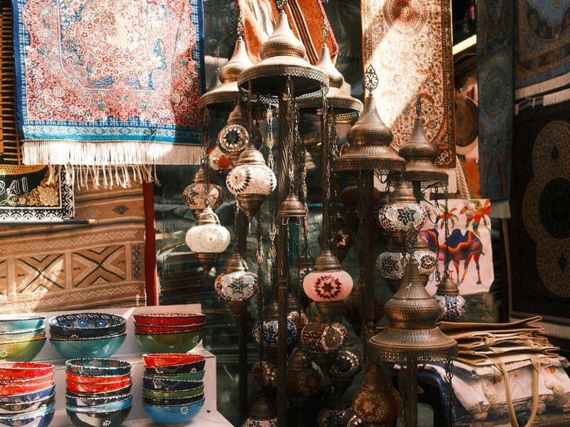 Colorful pottery and decorative items displayed in a market setting with intricate patterns.