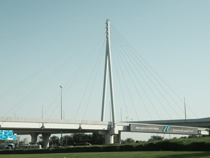 A modern cable-stayed bridge with a tall central pylon against a clear sky.
