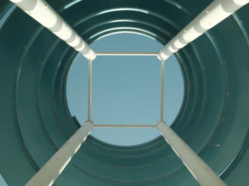 Looking up through a circular structure with a clear blue sky above.