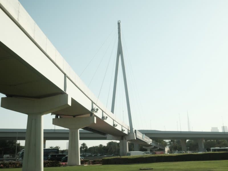 A modern cable-stayed bridge with a tall central pylon against a clear sky.