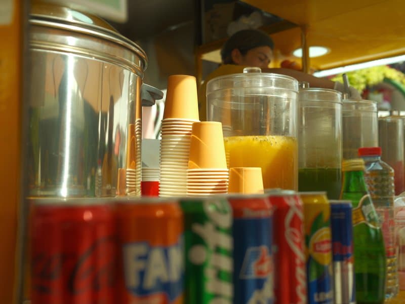 Colorful beverage display with cups and containers at a refreshment stand.