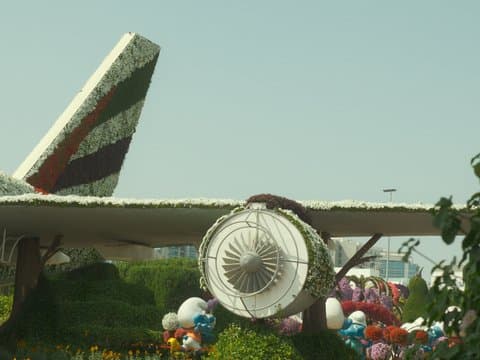 A floral display featuring an airplane tail and engine surrounded by colorful decorations.