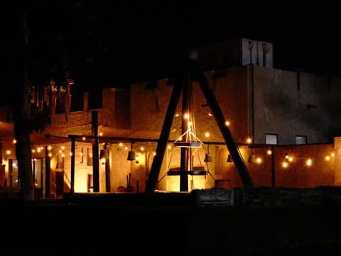 A rustic building illuminated by warm lights at night, creating a cozy atmosphere.