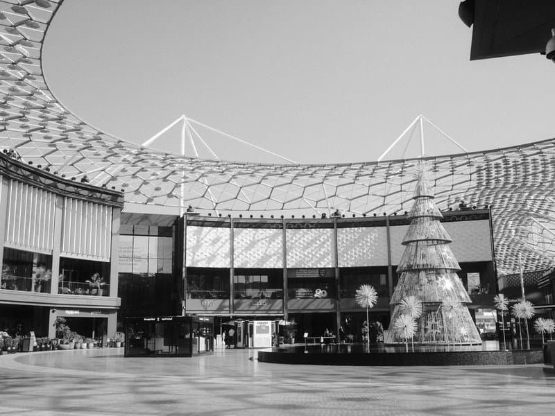 Interior of a modern shopping mall with a large Christmas tree and a unique patterned roof.