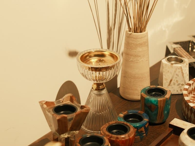 A collection of decorative vases and candle holders on a wooden table with soft lighting.