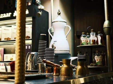 A cozy coffee shop counter with various coffee equipment and decorative elements.
