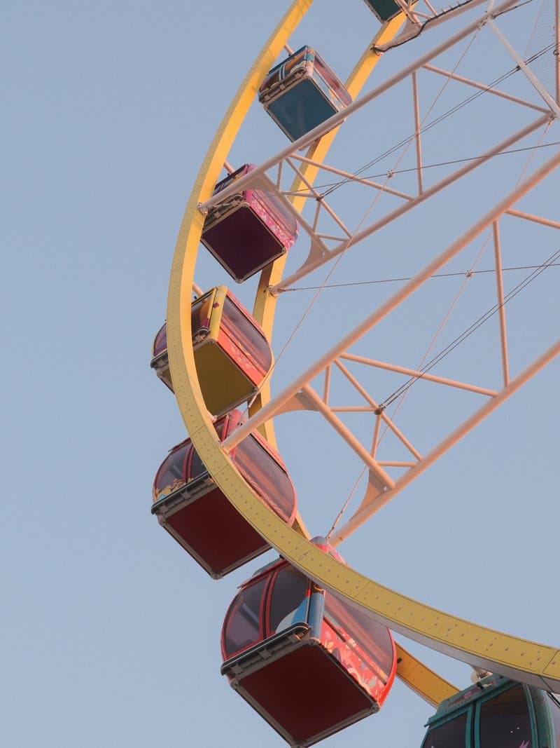 Close-up of a colorful ferris wheel against a clear sky.
