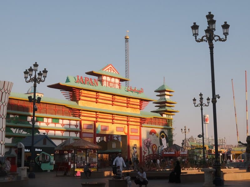 Colorful amusement park entrance with Asian-inspired architecture under a clear sky.