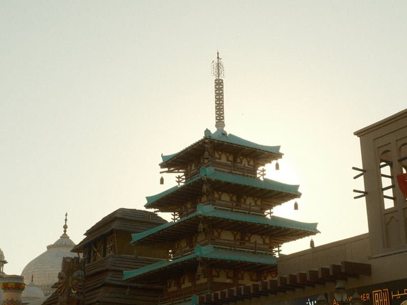 Silhouette of a pagoda against a bright sky, with architectural details visible.
