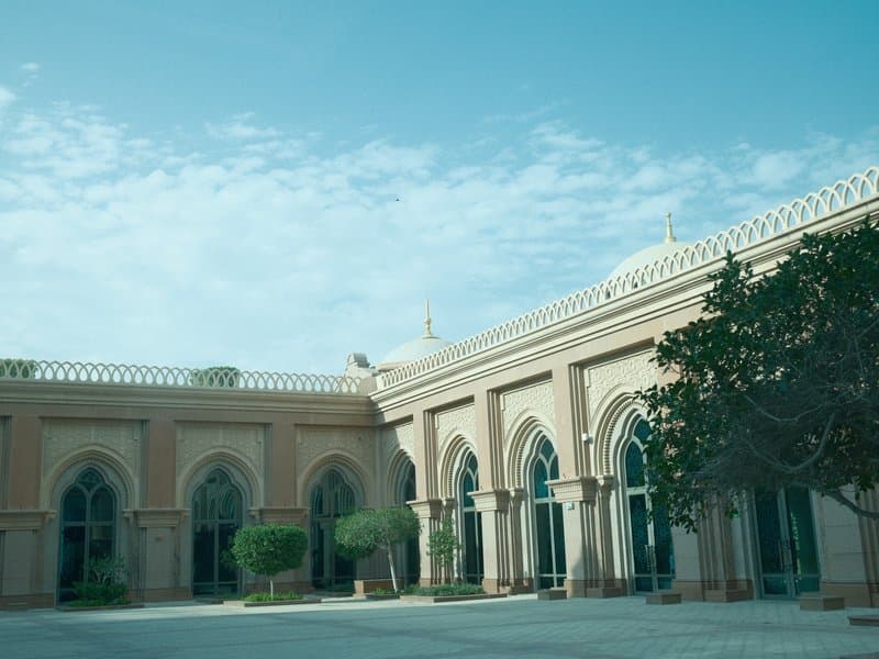 A historic building with arched windows and a clear blue sky in the background.